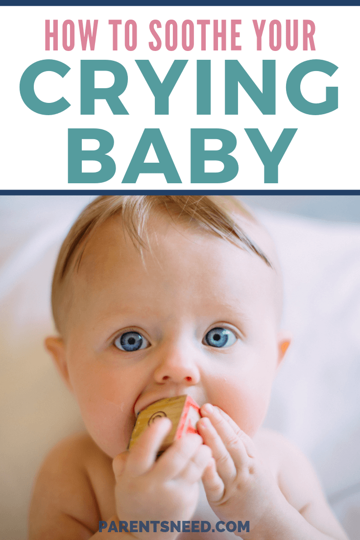 Baby self soothing on an alphabet toy block.