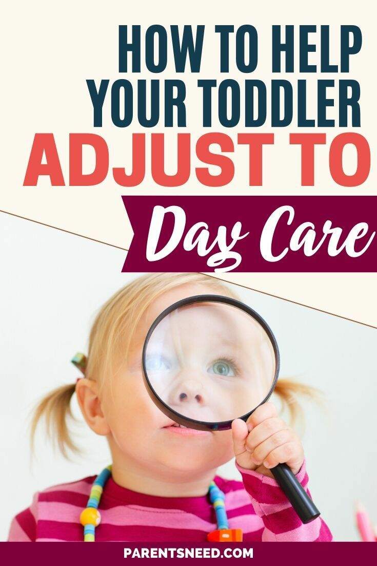 A toddler looking through a magnifying glass at daycare