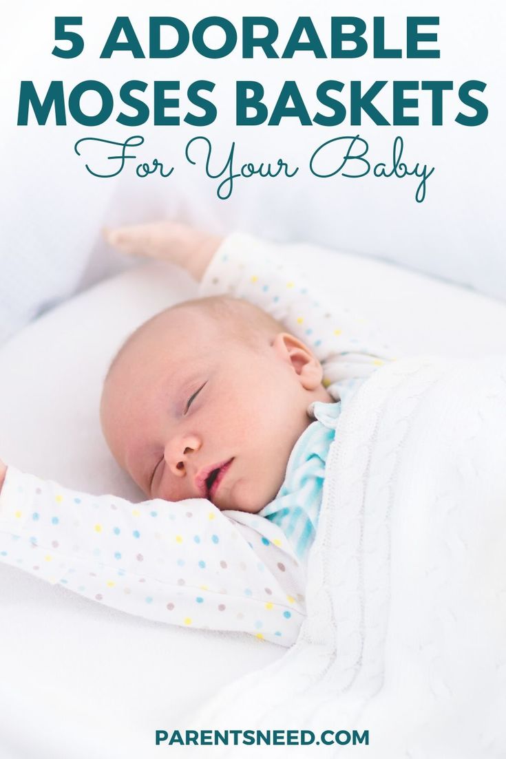 a baby stretching out in his moses basket