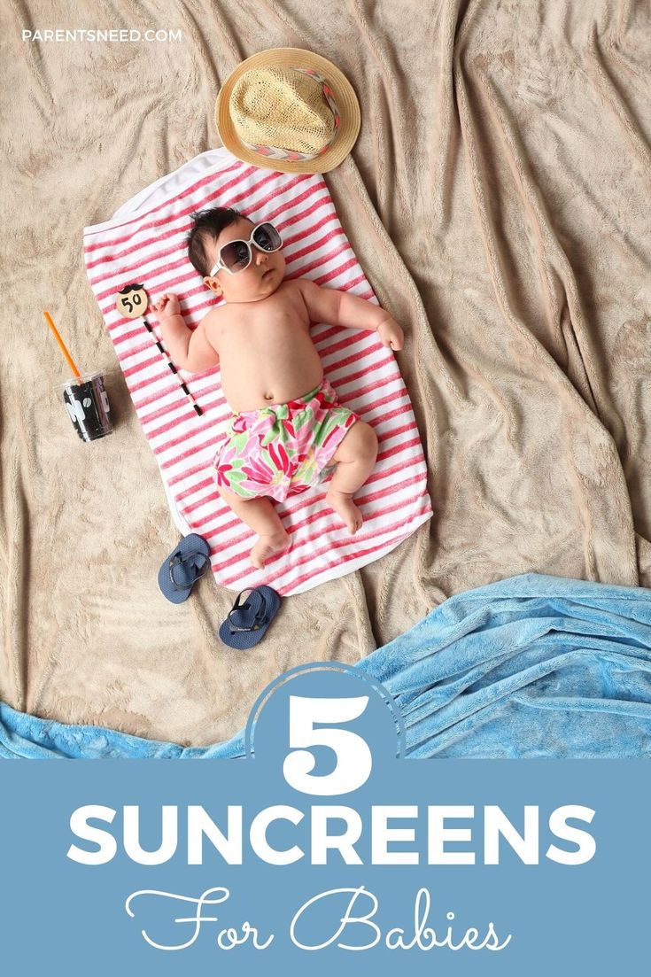 baby lying on a blanket at the beach